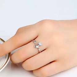 Imagen de anillo con silueta de gato y cola enrosacada en dedo acabada en corazón con incrustaciones brillantes